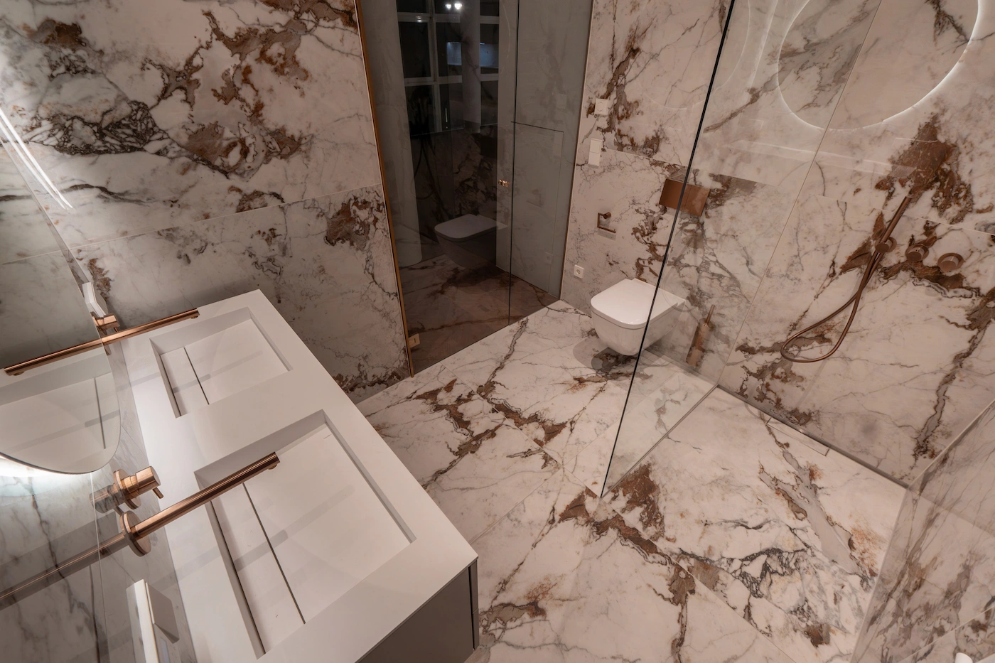 Badezimmer mit Natursteinverkleidung und bodengleicher Dusche