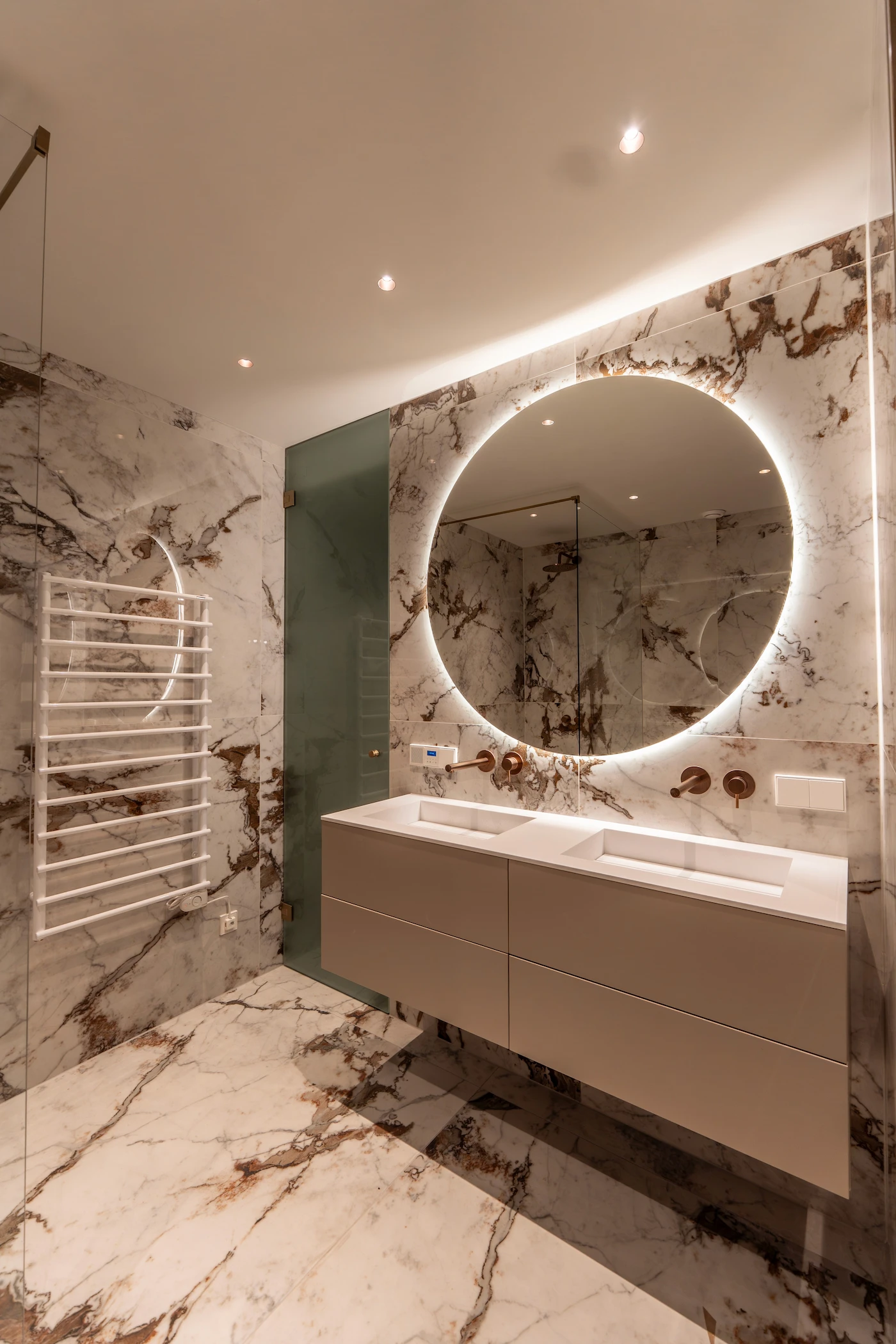 Waschtisch mit Rundspiegel und Naturstein im Badezimmer