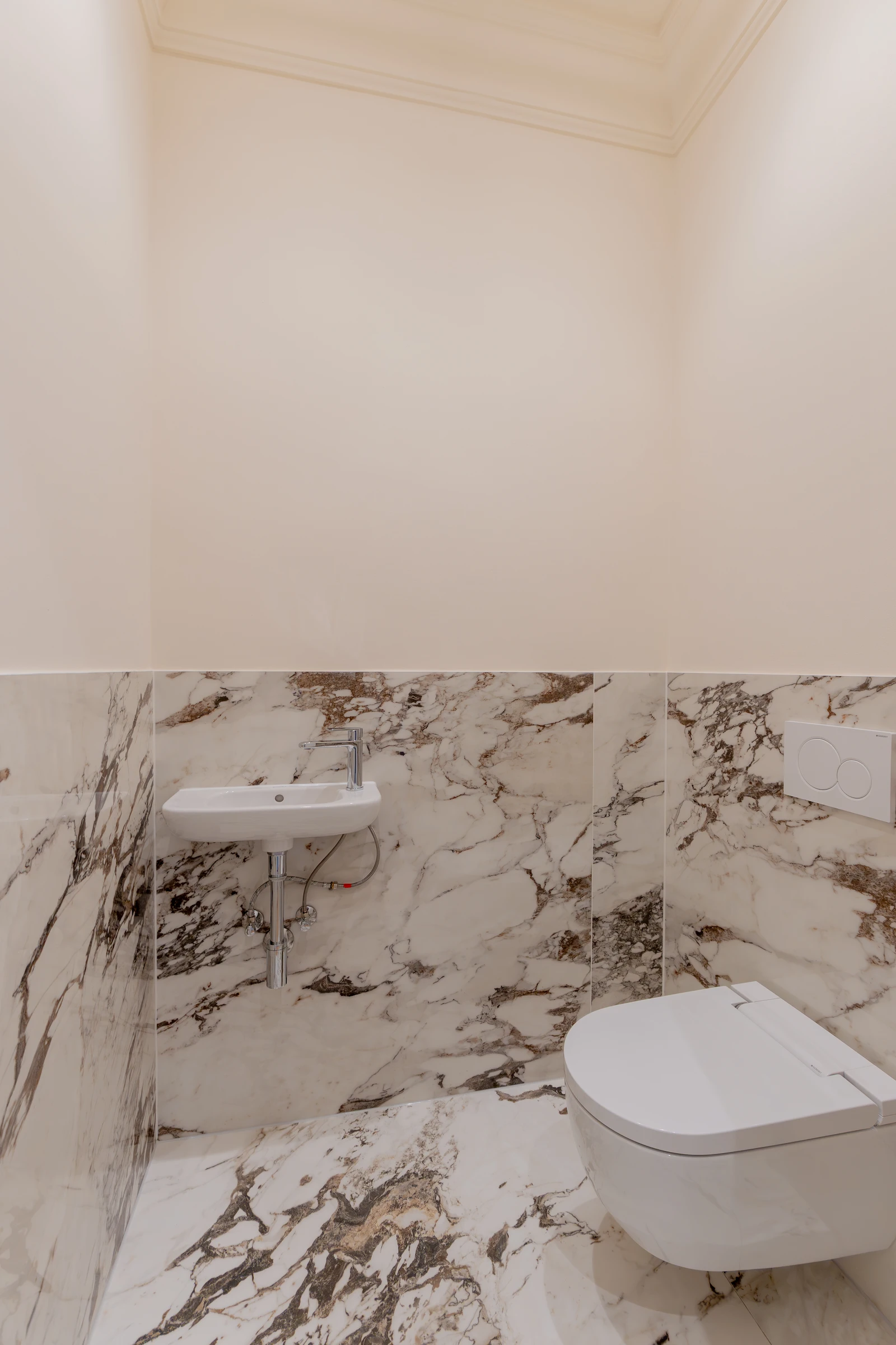 Gäste-WC mit Natursteinoberflächen in einer sanierten Altbauwohnung
