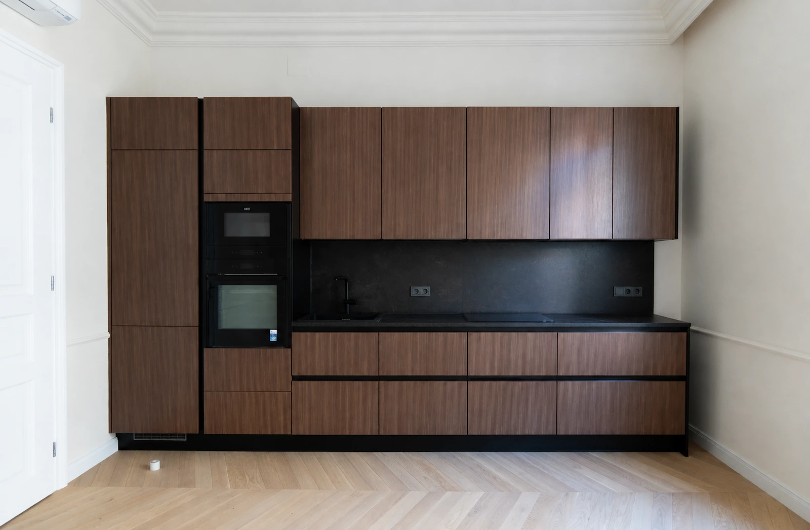 Maßgefertigte Küche mit dunklem Holzeinbau in einer Altbauwohnung