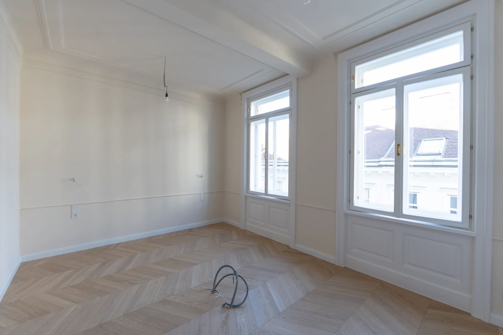 Helles Zimmer einer sanierten Altbauwohnung mit großer Fensterfront