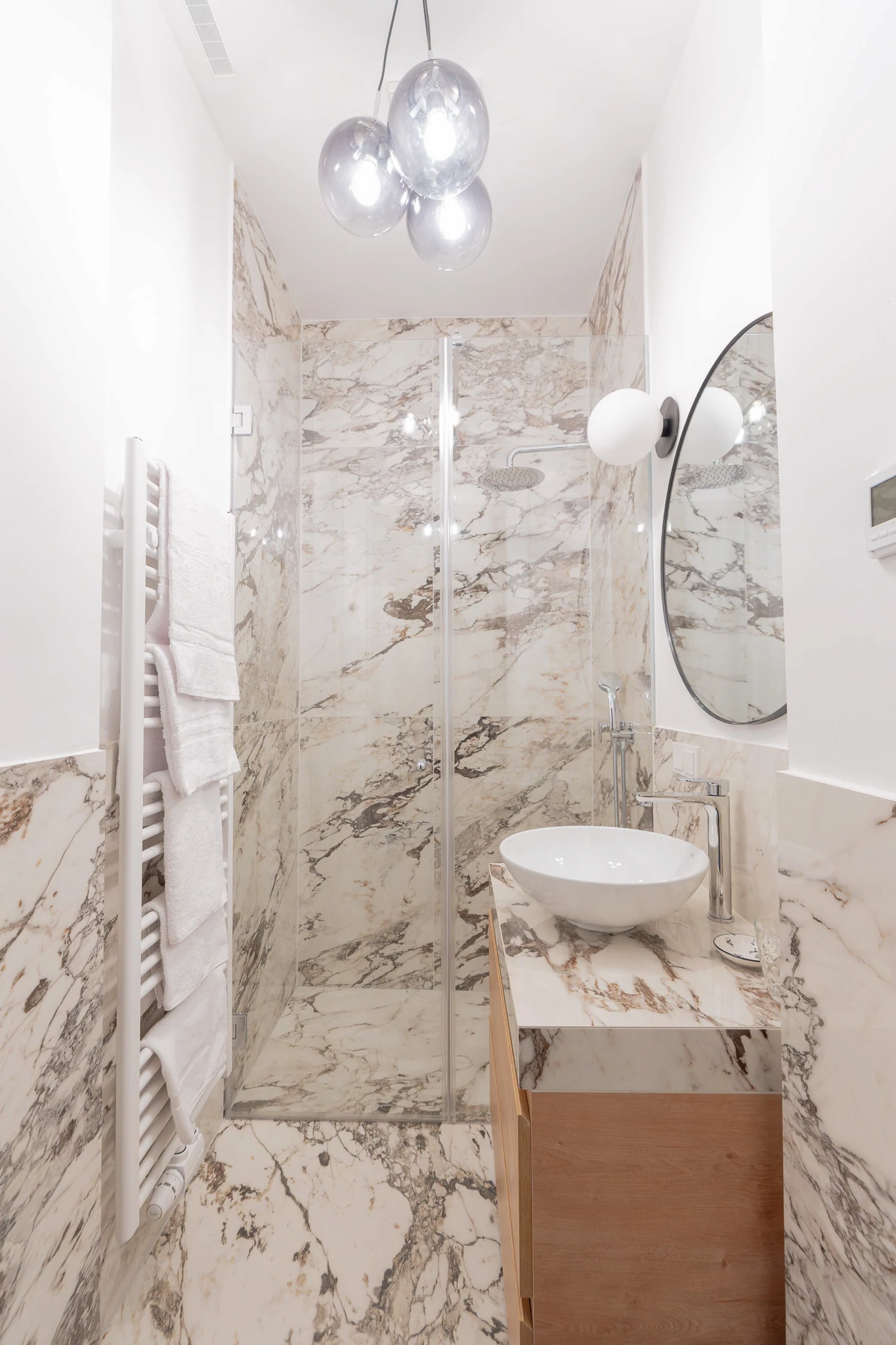 Badezimmer mit Natursteinoberflächen und bodengleicher Dusche