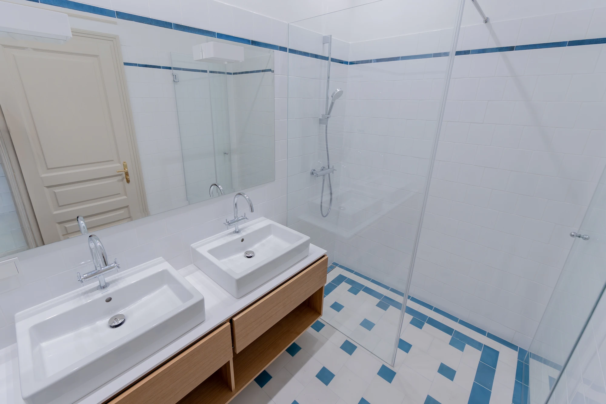 Badezimmer mit Doppelwaschtisch und bodengleicher Dusche