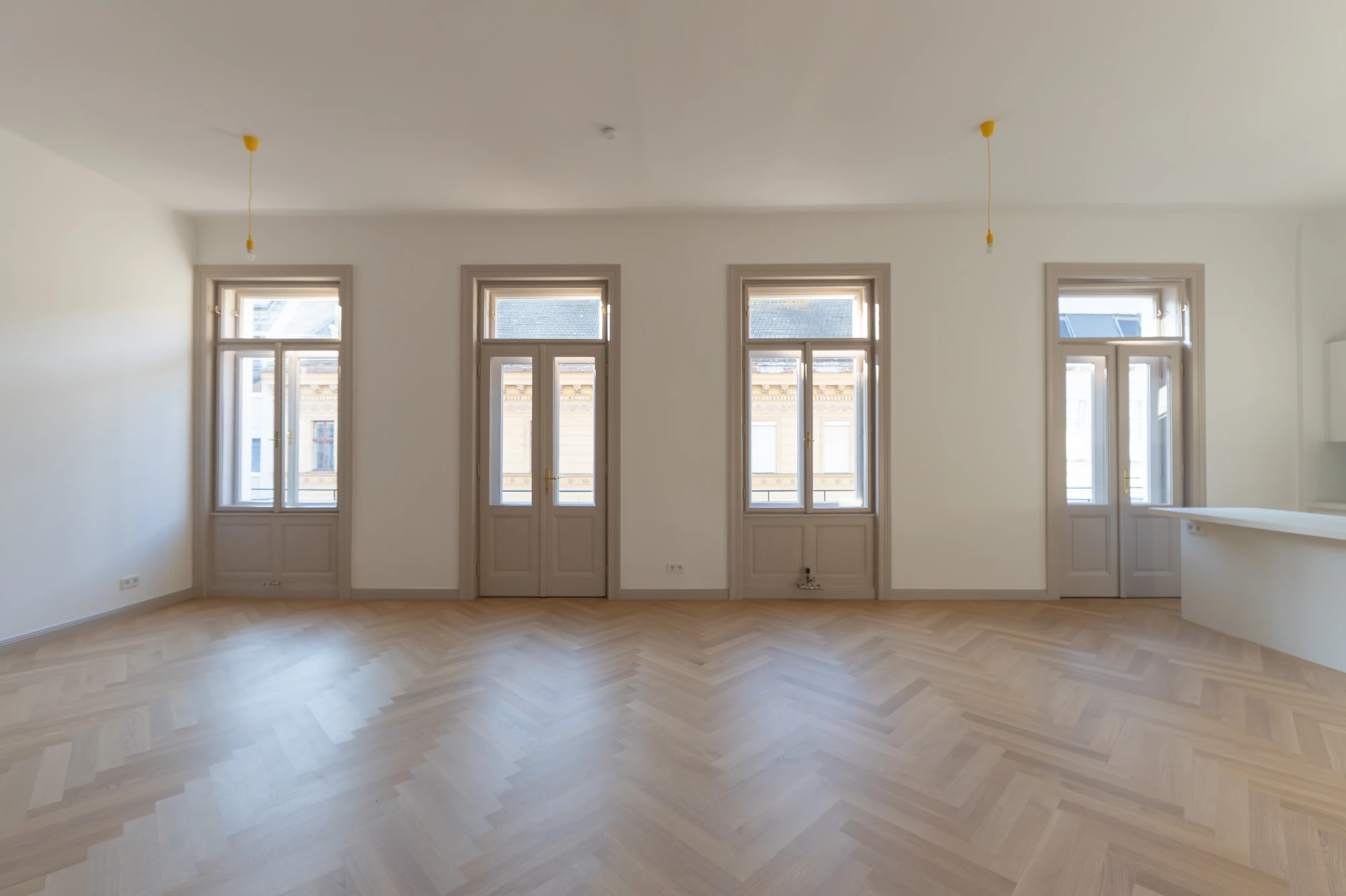 Großzügiger Wohnraum einer sanierten Wohnung in der Wohllebengasse mit Fensterfront und Fischgrätparkett