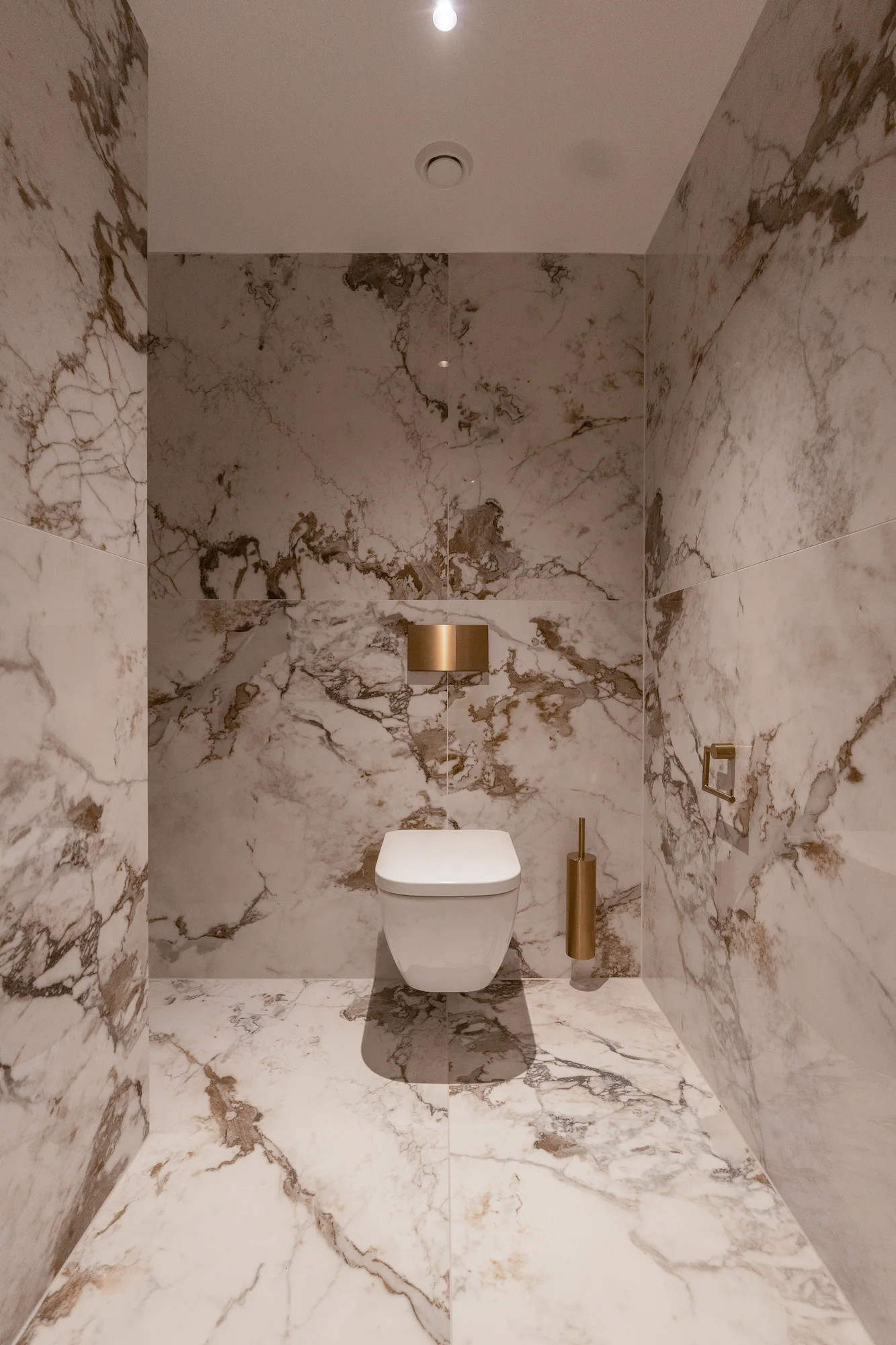 Gäste-WC mit Natursteinoberflächen und reduziertem Innenausbau
