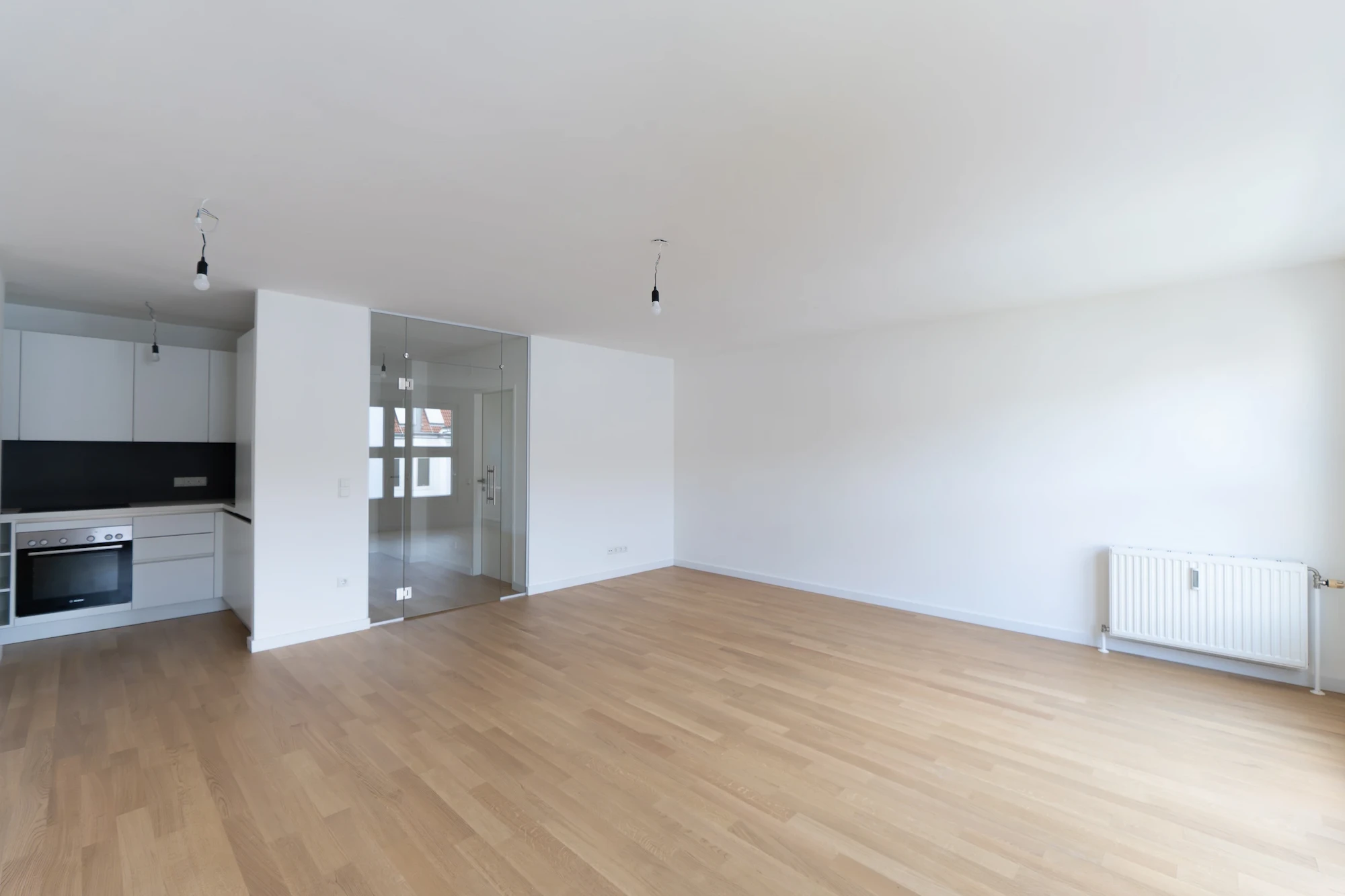 Heller Wohnraum einer sanierten Wohnung in Wien mit offener Küche